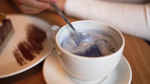 Close up of Person Stirring Blue Tea