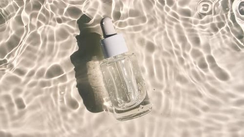 Elegant Clear Bottle with Dropper on Reflective Water