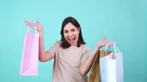 Woman Smiles with Shopping Bags on Bright Background