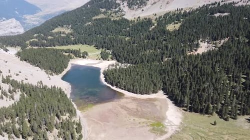 Horizontale Luftaufnahmen eines Sees in einer grünen natürlichen Umgebung mit Bergen im spanischen Pyr