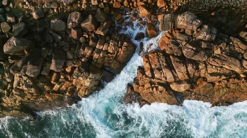 Aerial Vivid Blue Waves Crashing Against Tropical Coastline Birdeye View Dynamic Water Movement