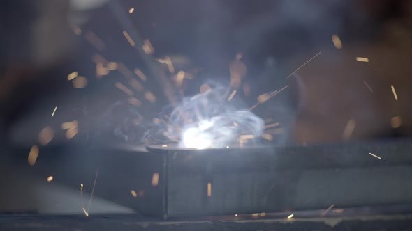 Sparks explode away as welder fuses a joint together- abstract tight ...