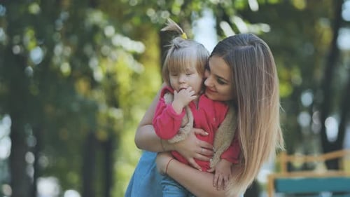 A Happy Mother with Her Young Daughter in the Park