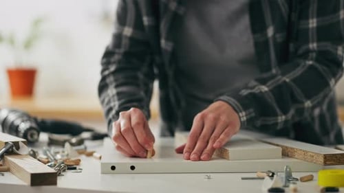 Montage, weibliche Hände bauen selbstbewusst und schnell vorgefertigte Möbel mit ihren eigenen Händen zusammen