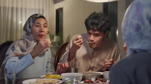 Asia muslim parent and their kids Ramadan dinner together in dining room at home.