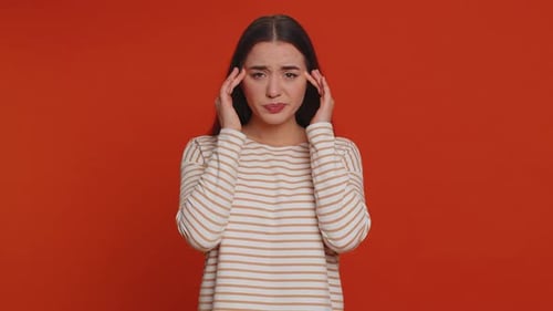 Woman Experiencing Headache Against Orange Background