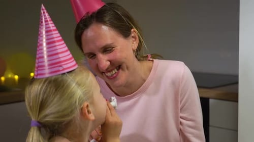 Woman and Child Celebrate Birthday With Noisemakers
