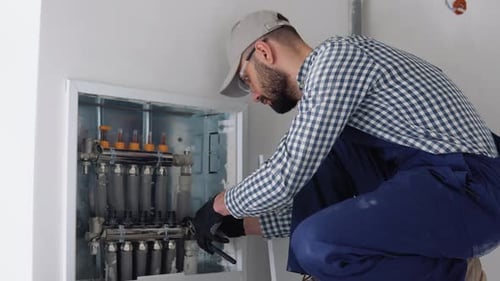 Heating Engineer Installing Modern Heating System in Boiler Room