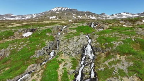 Fluss mit Wasserfällen fließt in der isländischen Sommersaison durch Berge