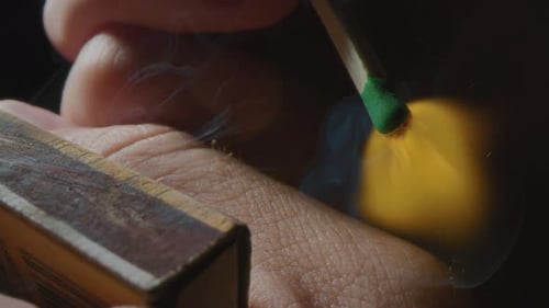 Hands Lights a Match with a Green Sulfur Head Slow Motion Strikes a Match on the Side of the Box