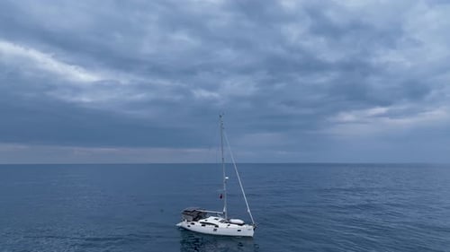 Segelyacht fährt bei Sonnenuntergang mit ruhiger Geschwindigkeit zum Hafen Luftbild