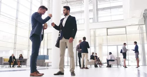 Happy business people, friends greeting with a fist bump in diverse corporate office
