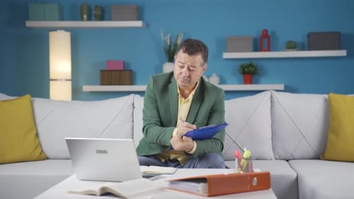 Home office worker man taking notes, jotting down information.