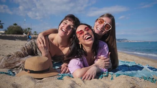 Three Joyful Friends Capturing a Lively Selfie on a Sunny Beach During a Funfilled Summer Day