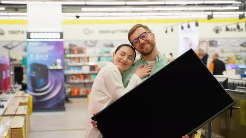Happy Couple with New Tv in Tech Store