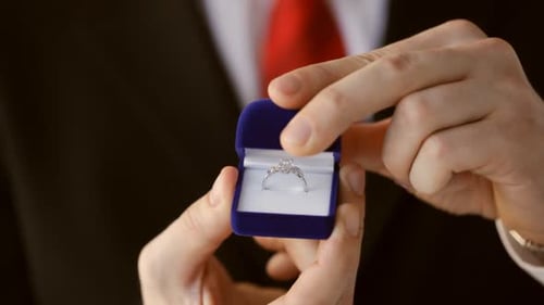 Close-up of man opening ring box