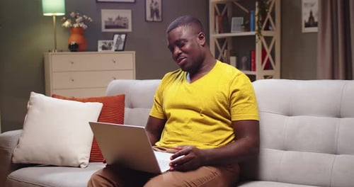 Man on Sofa Using Laptop Computer for Video Call