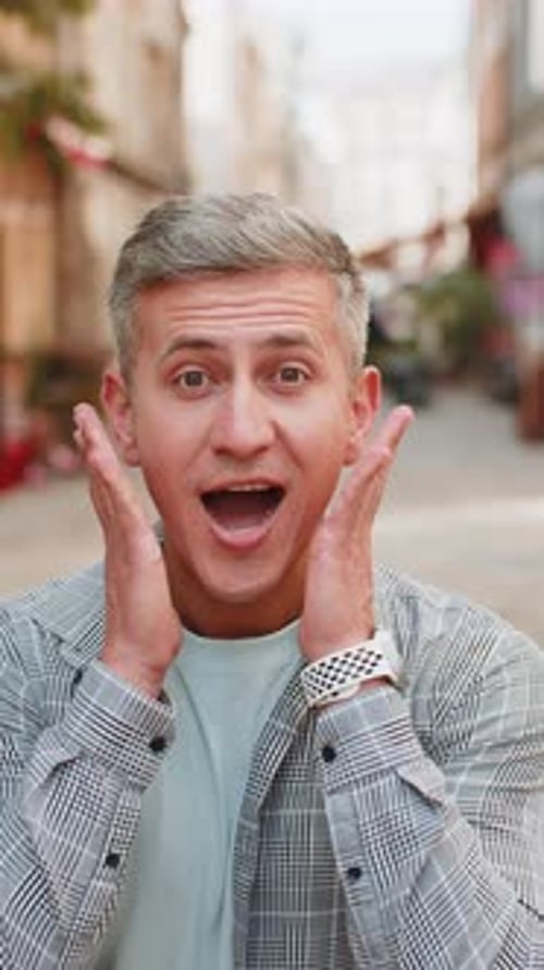 Mature Man Looking Surprised at Camera with Big Open Eyes Shocked By Sudden Victory on Street