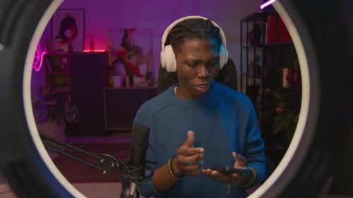 Joyous Black Male Influencer Trying Sound on New Headphones on Live Stream