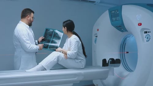 Doctor Shows X-Ray to Patient Near CT Scan