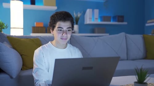 Young Adult Using Laptop Computer at Home