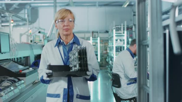 On High-Tech Factory Asian Engineer Uses Laptop Computer for Programing ...