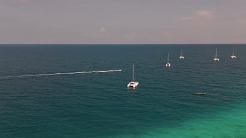 Motorboat Passed By The Catamaran And Yachts Floating In The Blue Sea In Zanzibar, Tanzania. - aeria