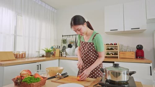 Asian young woman cooking healthy foods in kitchen in morning at home.