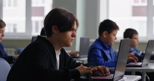 Konzentrierter Teenager, der im computergestützten Klassenzimmer der High School mit dem PC übt