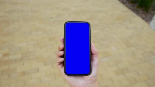 Man walking in city using smartphone green screen chroma key top point of view