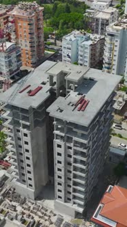 Fotografía vertical con un Zumbido de un edificio residencial inacabado con concreto expuesto y balcón amarillo