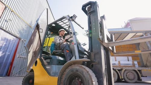 Male Forklift Driver Working on Loading and Unloading Goods in Storehouse