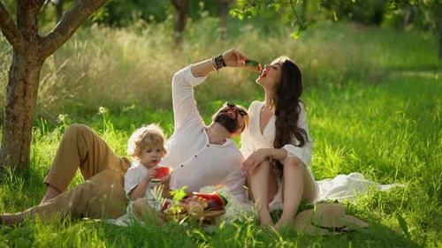 Family Picnic in Orchard on Sunny Day