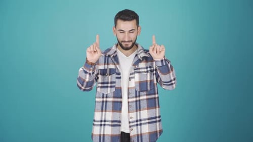 Man Gesturing and Pointing on Light Blue Background