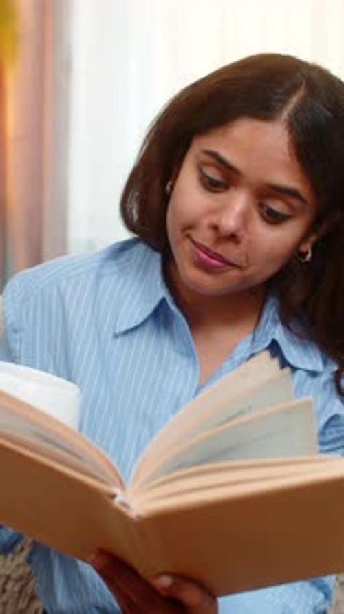 Woman Reading Book and Drinking Coffee at Home