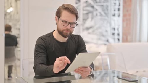 Cheerful Young Adult Man using Tablet PC