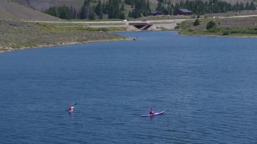 Drone view of 2 people doing kayak on a blue lake in Colorado