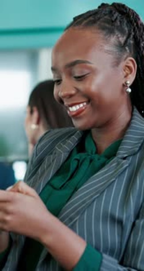 Smiling Woman with Braids Using Phone in Office