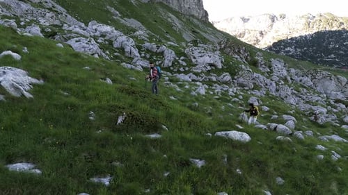 Hikers Ascending Rocky Mountain Slope