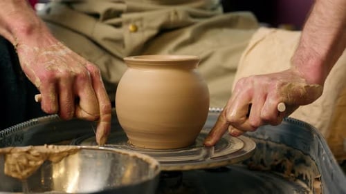 Tablier de maître tenant du fil, potier, argile, artisanat, artisan, découpant des récipients humides