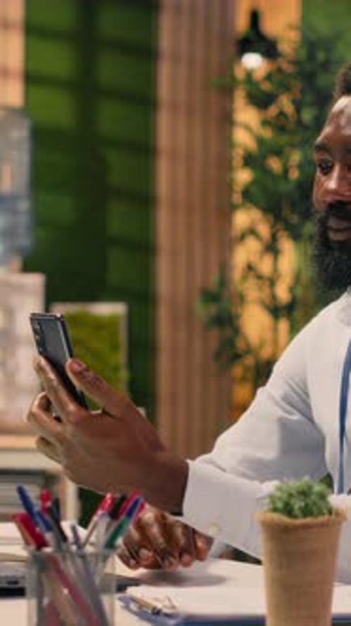 Vertical Video Black Worker Engaged in Video Conference Call with Global Team