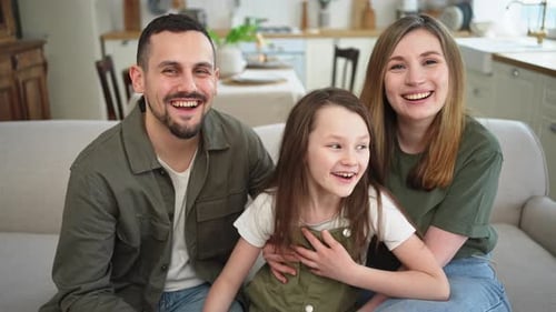 Happy Family Smiling Together on the Couch at Home