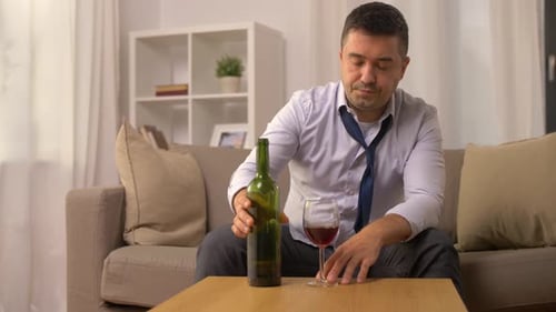 Sad Man Drinking Wine on Sofa