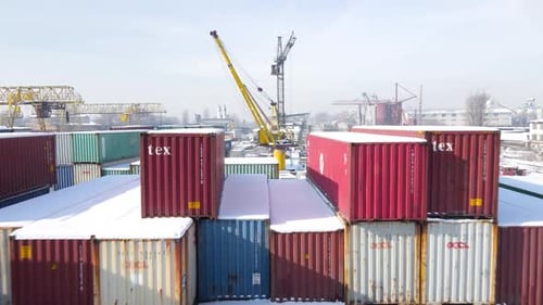 Versandcontainer und Frachtkran auf dem Lagerplatz im Winter, Luftaufnahme