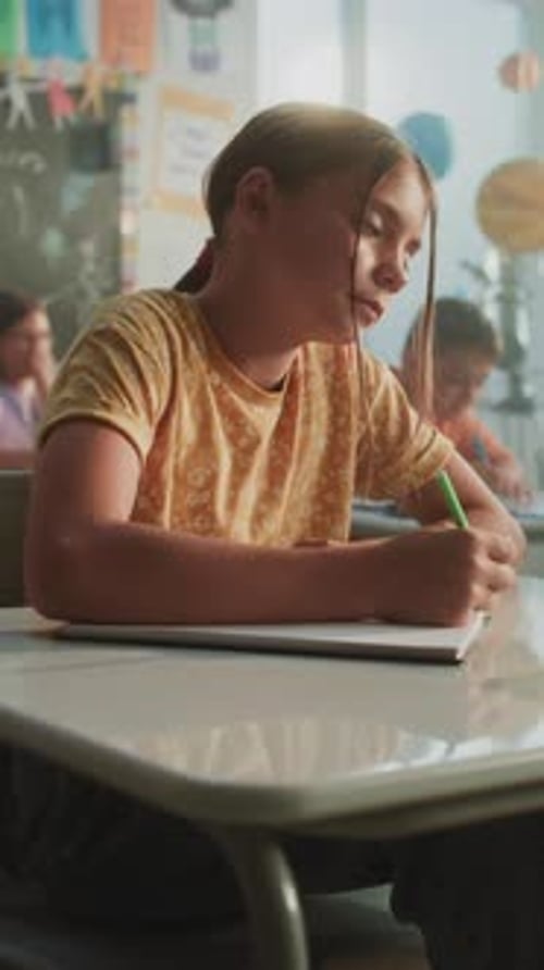 Elementary School Students Sitting at Desks Writing Exam or Lecture in Modern Classroom