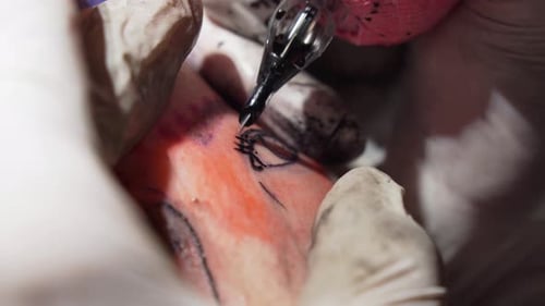 Tattoo Artist Creating Eyelash Tattoo