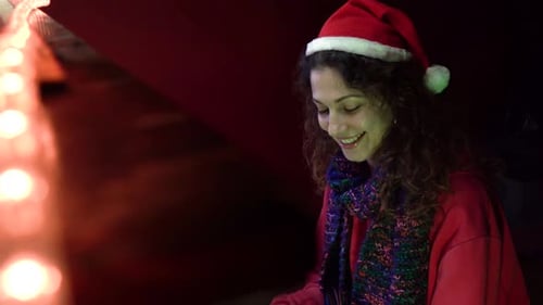 Woman Plays Piano Wearing a Santa Hat