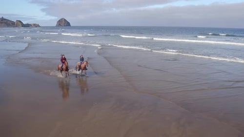 Aerial View Of Women Riding Horses At Beach