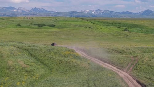 Black Suv Driving on Dirt Road in Scenic Mountain Valley