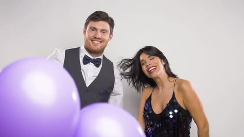 Festive Couple Celebrating and Dancing with Balloons Indoors